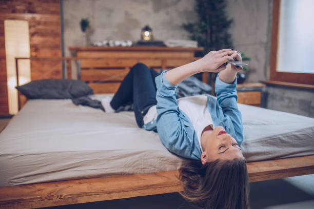 istock Woman using phone in bedroom 912348684