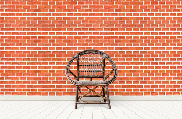 Wicker armchair / old chair on red brick wall background. decoration room interior
