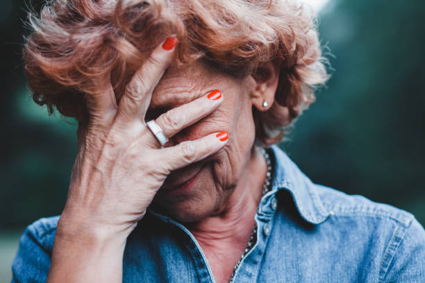 istock Older women worrying with her hands over her face 912353370