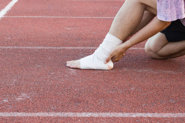 istock Male athlete applying compression bandage onto ankle injury 912353434