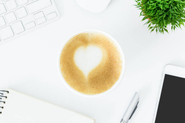 istock A latte coffee with art heart milk on the white desk table from top view and copy space. Flat lay with desk, business and valentine concept. 912353824