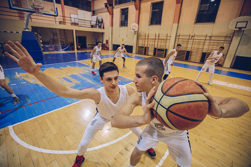 Group of male basketball players playing basketball