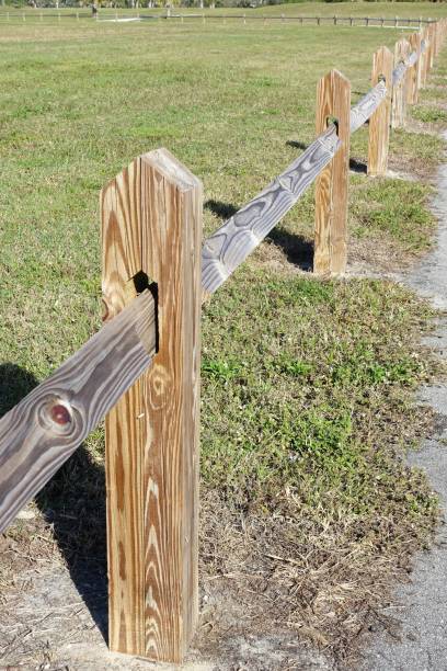 istock Split rail fence near walkway thru park green area 912359944