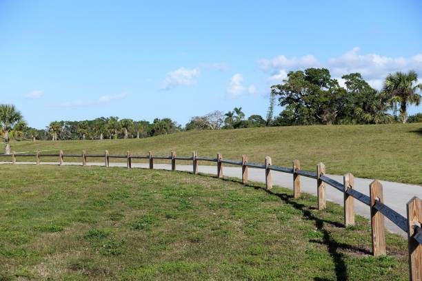 istock Split rail fence bordering walkway thru park green area 912360006