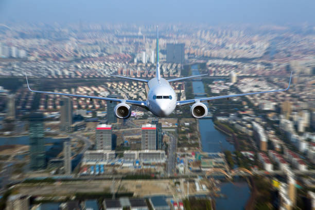 istock White passenger plane flyes above the city. 912360388