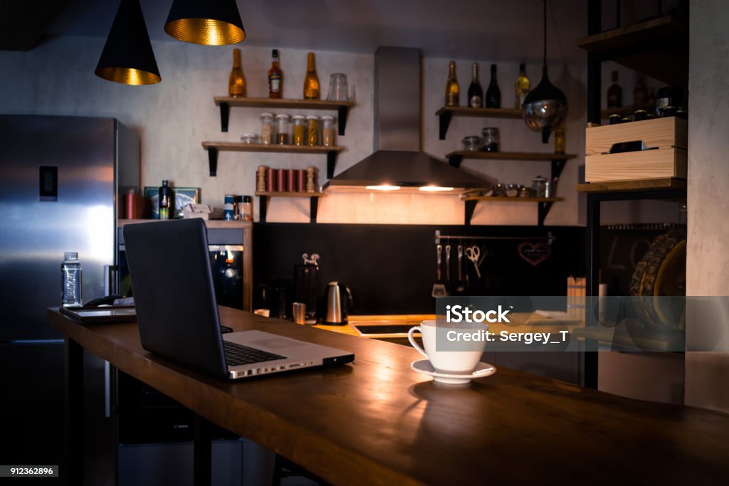 Kitchen with bar counter Kitchen with bar counter. Home atmosphere, work in the evening after a hard day with cup of coffee. Home office. Night Stock Photo