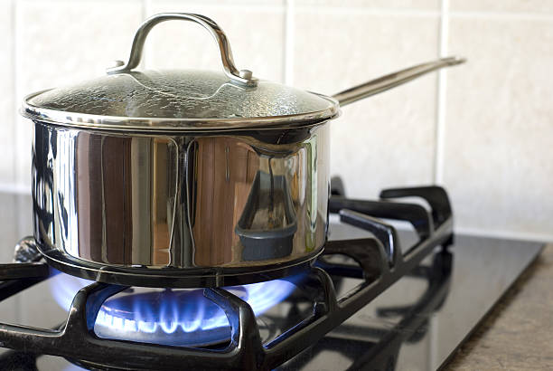 cucinare su una stufa a gas - fornello foto e immagini stock