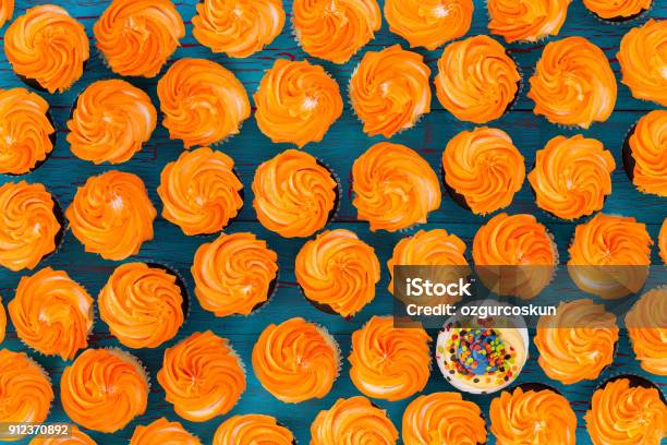 Background Pattern Of Glazed Orange Cupcakes Stock Photo - Download Image Now - Standing Out From The Crowd, Individuality, Concepts