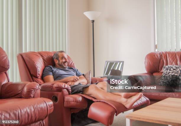 Happy Male Seated In Reclining Chair In A Living Room Stock Photo - Download Image Now