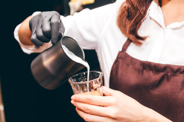 istock Barista holding milk for make coffee latte art in coffee shop 912379464