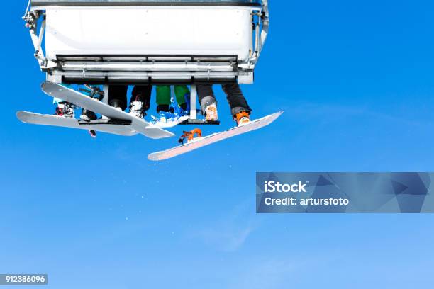 Skiers Going Up On The Chairlift Against Bright Blue Sky Ski Resort In Italy On Sunny Winter Day Stock Photo - Download Image Now