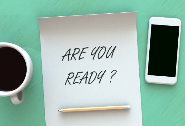 istock ARE YOU READY, message on paper, smart phone and coffee on table, 3D rendering 912389794
