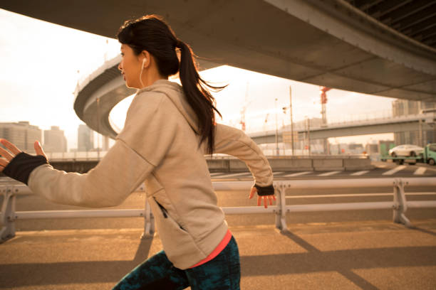 istock A woman running beside the road. 912392830