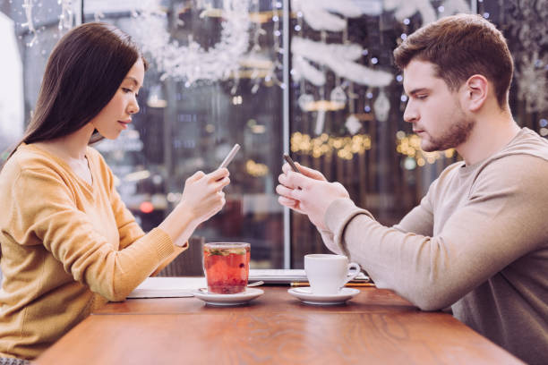 istock Focused young couple emerging in phones 912393752