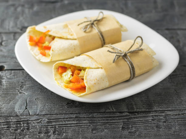 istock Two vegetable roll tortilla from wheat flour in white bowl on a table. 912397008