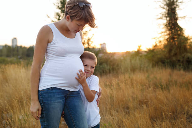 istock Pregnant mother hugging her son 912397028