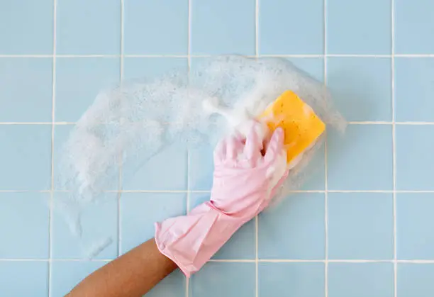 Hand in pink glove with sponge washing