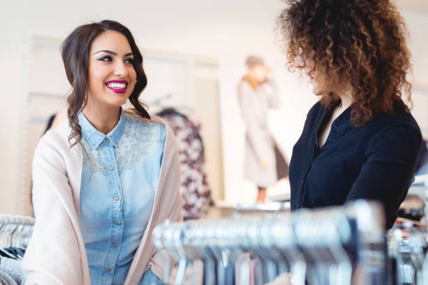 istock Two cheerful girls shopping for clothes 912400550
