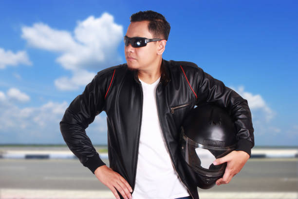 biker riding a classic sports motorcycle dressed in leather biker overalls