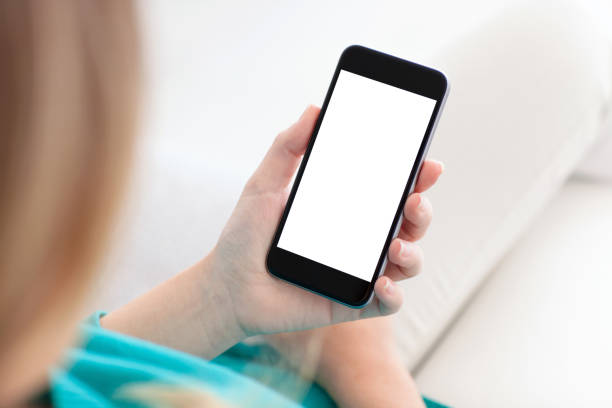 istock woman holding a phone with isolated screen on a sofa 912409746