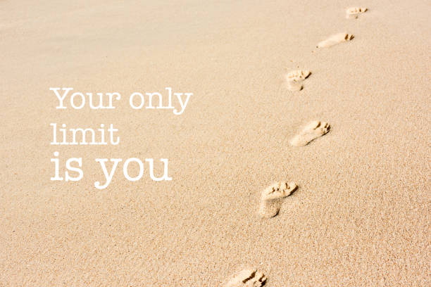 Inspirational motivation quote footprints on beach sand