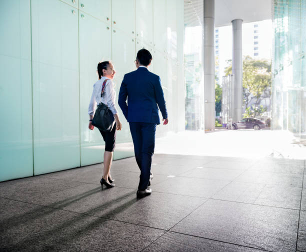 istock Asian business people discussing while walking 912412308