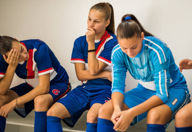 Depression after lost match! Group of teenage soccer players feeling disappointed after loosing the match. woman defeat stock pictures, royalty-free photos & images