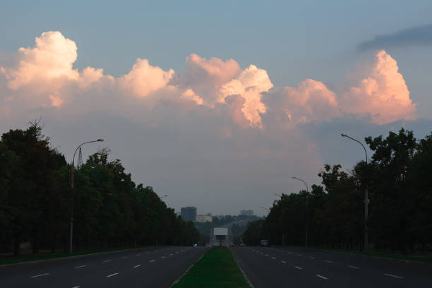 Countryside. Evening suburbian road with pink sunset clouds in sky