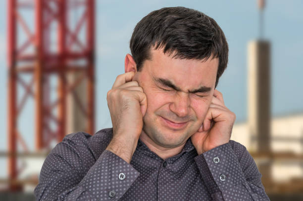 Man covering his ears to protect from loud noise Man covering his ears to protect from loud noise - excessive sound man closing ears photos stock pictures, royalty-free photos & images
