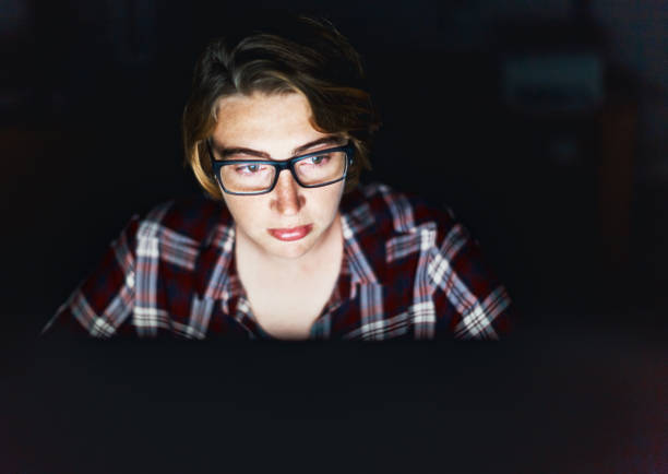 istock Studious young woman in glasses works late on computer 912422354