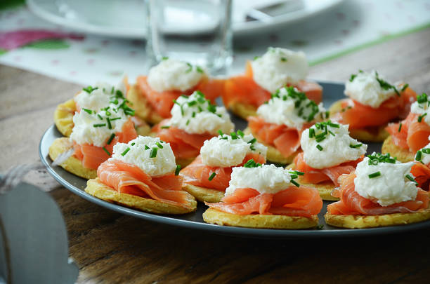 smoked salmon on small pancakes with horseradish cream - bite size imagens e fotografias de stock