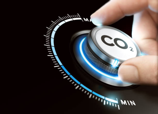 Reduce Carbon Dioxide Footprint. CO2 Removal Man turning a carbon dioxide knob to reduce emissions. CO2 reduction or removal concept. Composite image between a hand photography and a 3D background. carbon dioxide stock pictures, royalty-free photos & images