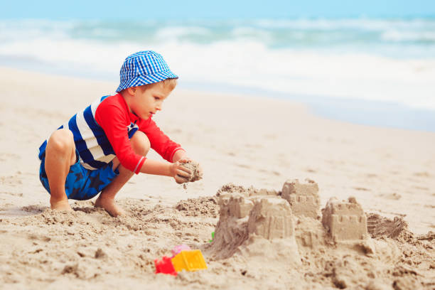 istock little boy play with sand on beach 912427158