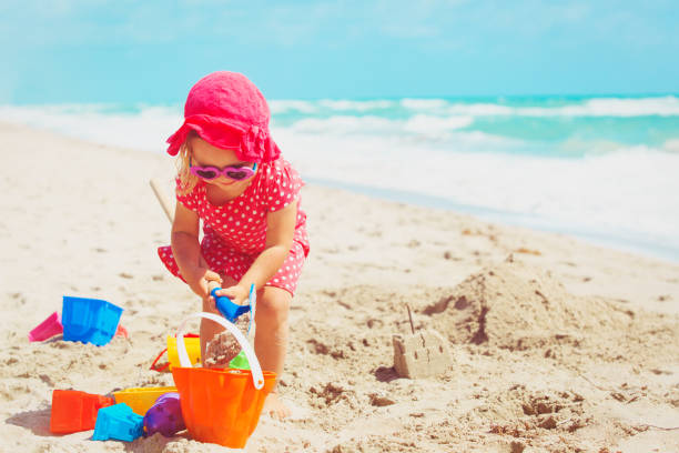 istock cute little girl play with sand on beach 912427232