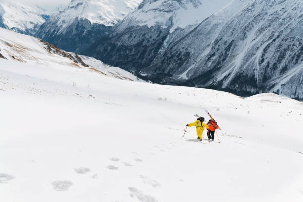 istock two ski freerider climbs the slope into deep snow powder with the equipment on the back fixed on the backpack 912434364