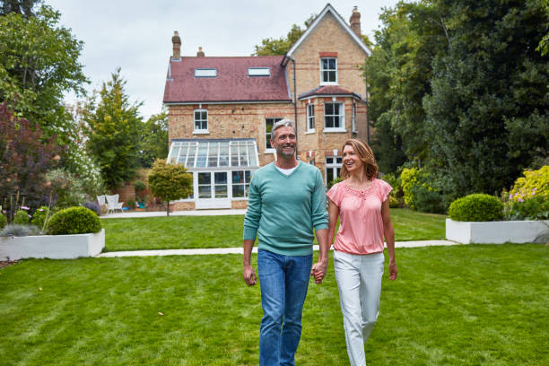 istock Smiling mature couple walking against house 912438044