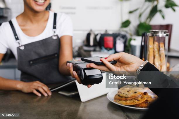 Cliente Haciendo Pago Inalámbrico Con Smartphone En Café Foto de stock y más banco de imágenes de Pagar