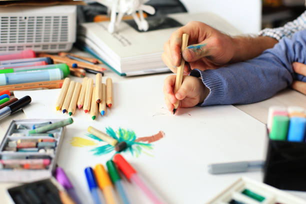 istock Dad teaches young son to draw 912442534