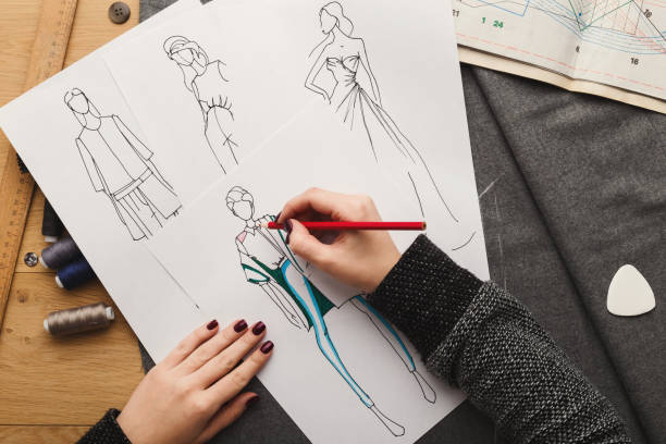 istock Top view on woman designer drawing clothes sketches 912443048