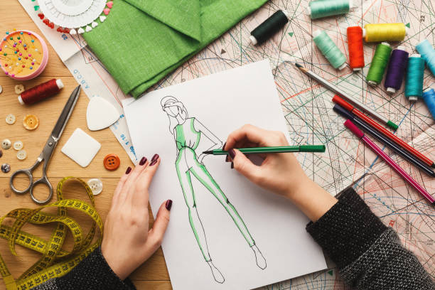 istock Top view on woman designer drawing clothes sketches 912443374