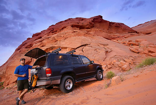 istock man with SUV and sandstone desert landscape 91244522