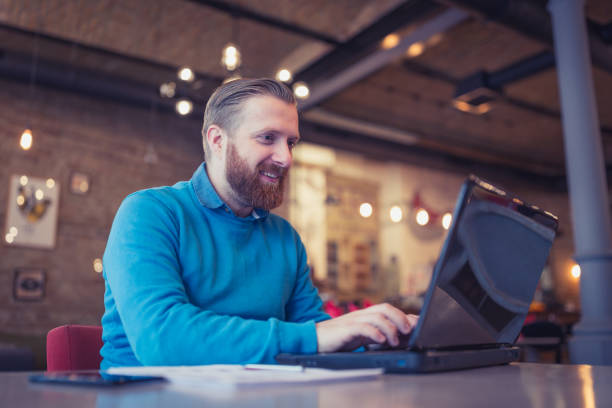 istock Young, redhead businessman, on coffee break working using laptop 912450478