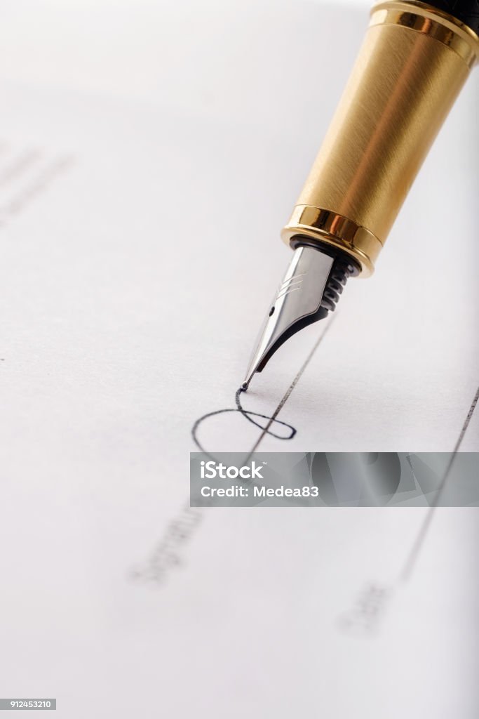 Close-up of gilded fountain pen signing contract, document. Vertical image. Close-up of gilded fountain pen signing contract, document on white background. Vertical image. Signing Stock Photo