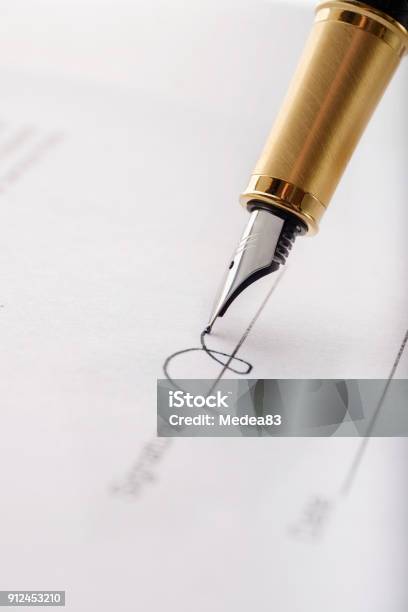 Closeup Of Gilded Fountain Pen Signing Contract Document Vertical Image Stock Photo - Download Image Now