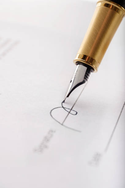 close-up of gilded fountain pen signing contract, document. vertical image. - employ imagens e fotografias de stock