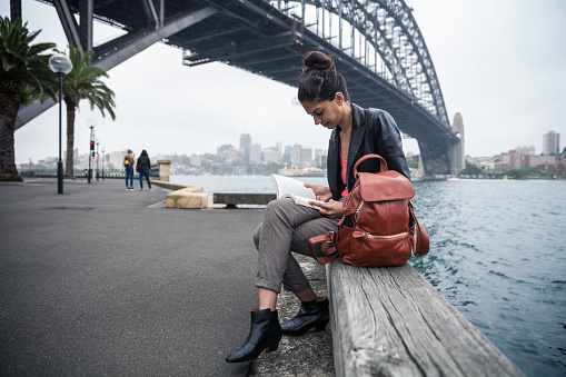 Indian woman in the city of Sydney reading a book