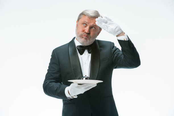 istock Senior waiter holding bell 912457398