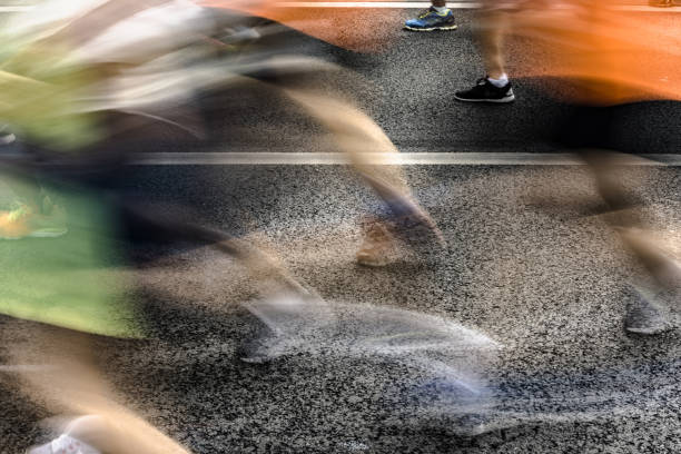 istock People running in marathon on city streets. Motion blur. 912458160