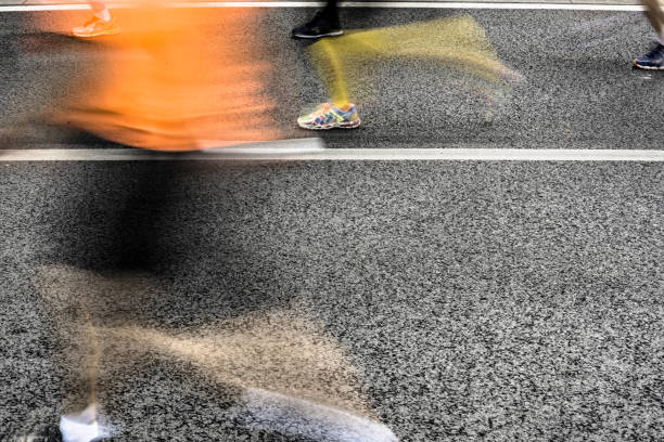 istock People running in marathon on city streets. Motion blur. 912458236