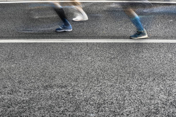 istock People running in marathon on city streets. Motion blur. 912459802